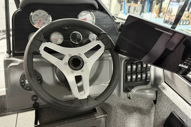 Slide: The Image of Steering console of 2027 Starcraft Fishmaster 210 with gauges and Humminbird display. - 8