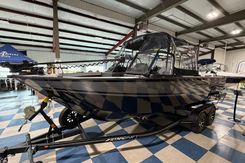 The Image of 2027 Starcraft Fishmaster 210 boat on trailer in showroom, featuring sleek design and modern equipment. - 0