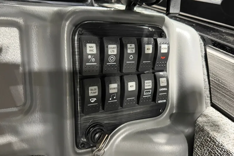 Slide: The Image of Control panel of 2027 Starcraft Fishmaster 210 boat with labeled switches. - 11