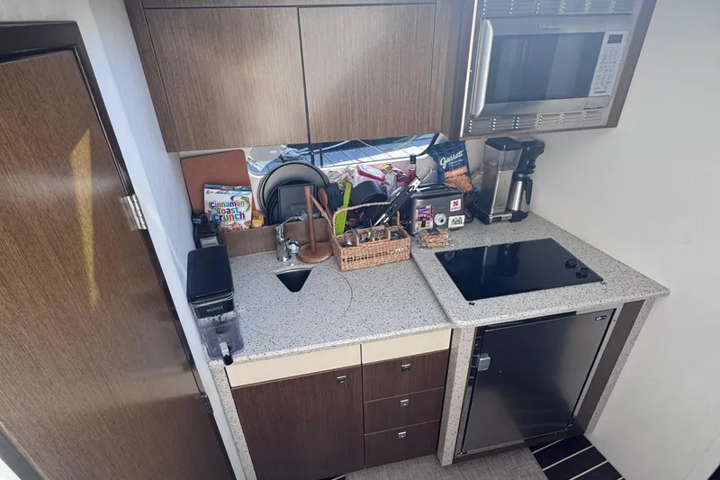 Slide: The Image of Compact kitchen area in a 2012 Cruisers Yachts 41 Cantius, featuring modern appliances. - 41