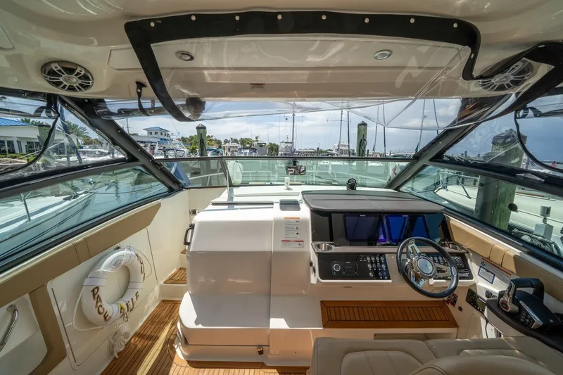 Slide: The Image of 2025 Sea Ray Sundancer 320 Outboard helm with modern controls and panoramic marina view. - 17