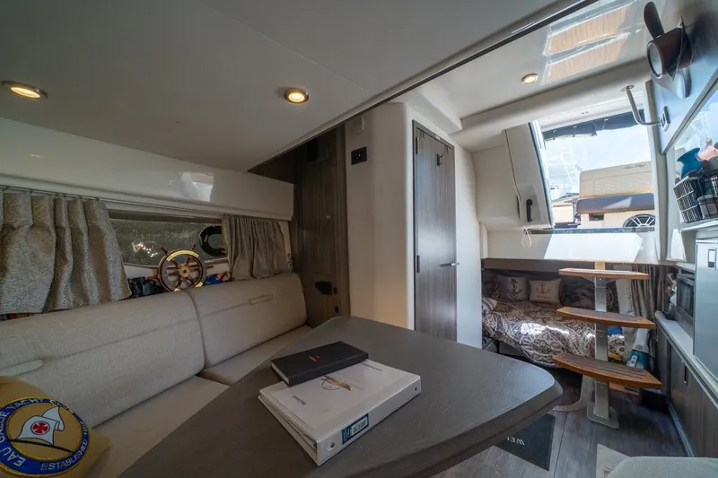 Slide: The Image of Interior of 2025 Sea Ray Sundancer 320 Outboard, featuring cozy seating and modern design. - 23