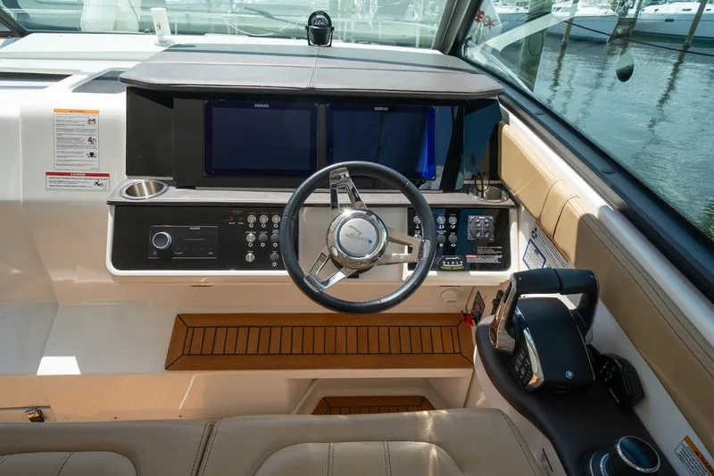 Slide: The Image of 2025 Sea Ray Sundancer 320 Outboard helm with modern controls and navigation displays. - 15