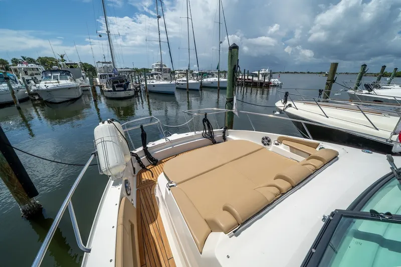Slide: The Image of 2025 Sea Ray Sundancer 320 Outboard docked at marina, featuring spacious sun deck. - 19