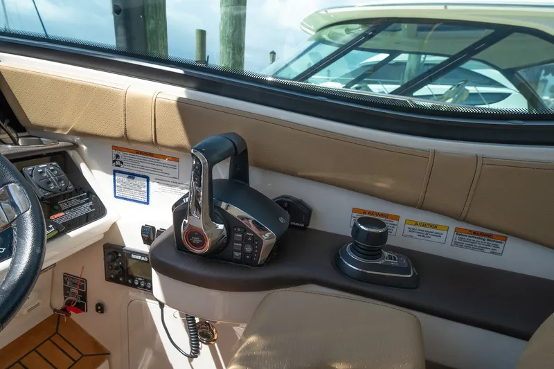 Slide: The Image of 2025 Sea Ray Sundancer 320 Outboard helm with controls and navigation equipment. - 16