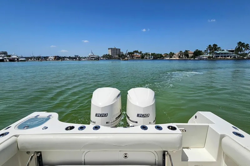 Slide: The Image of 2014 Sailfish 320 CC boat with dual 300 horsepower engines on calm water. - 15