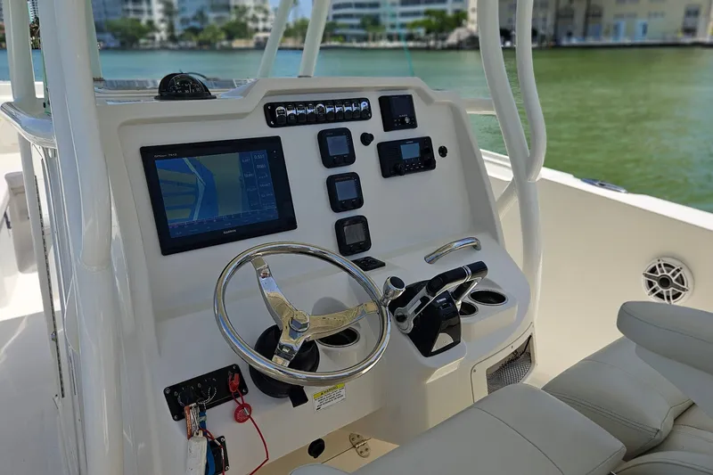 Slide: The Image of 2014 Sailfish 320 CC boat dashboard with steering wheel and navigation controls. - 17