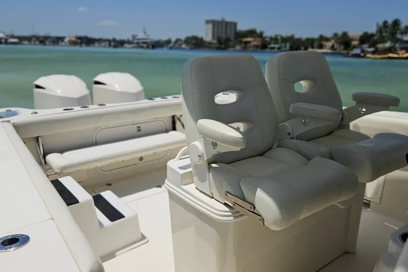 Slide: The Image of 2014 Sailfish 320 CC boat interior with dual captain's chairs and scenic water view. - 20