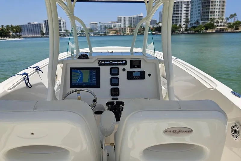 Slide: The Image of 2014 Sailfish 320 CC boat cockpit with navigation system, overlooking waterfront cityscape. - 16