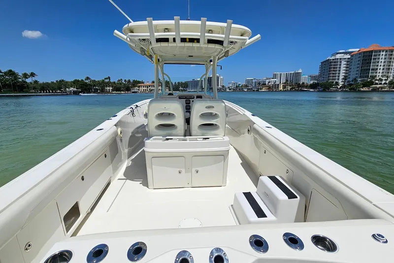 Slide: The Image of 2014 Sailfish 320 CC boat on calm water, featuring spacious deck and modern design. - 19