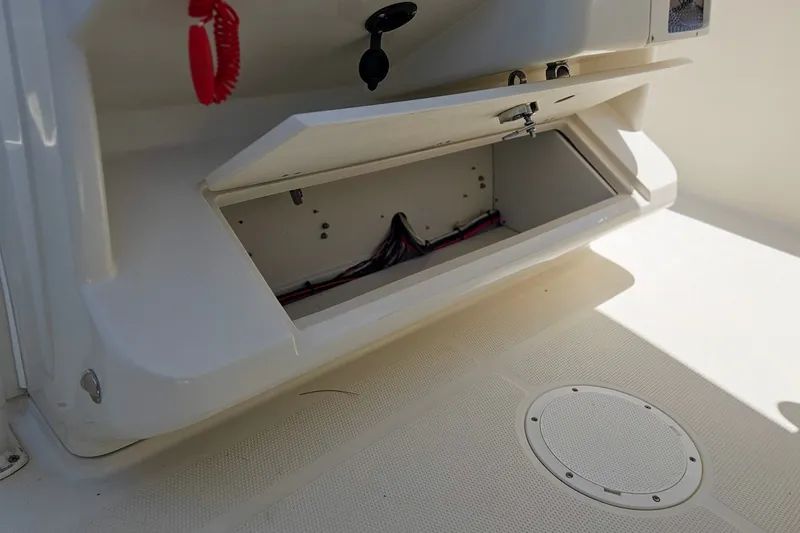 Slide: The Image of Open storage compartment on a 2014 Sailfish 320 CC boat, showing interior wiring. - 24