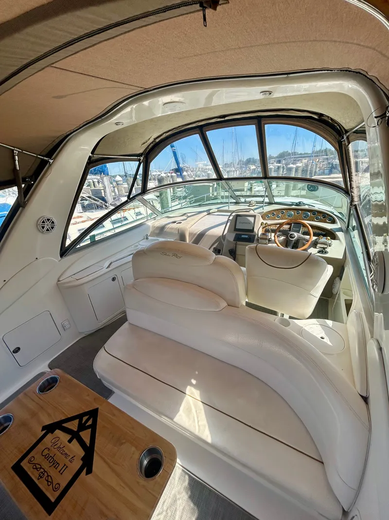 Slide: The Image of The image shows the cockpit of a 1999 Sea Ray 340 Sundancer with beige seating and a wooden table. - 25