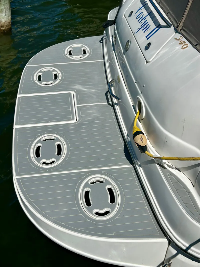 Slide: The Image of The image shows the stern of a 1999 Sea Ray 340 Sundancer with gray decking. - 30