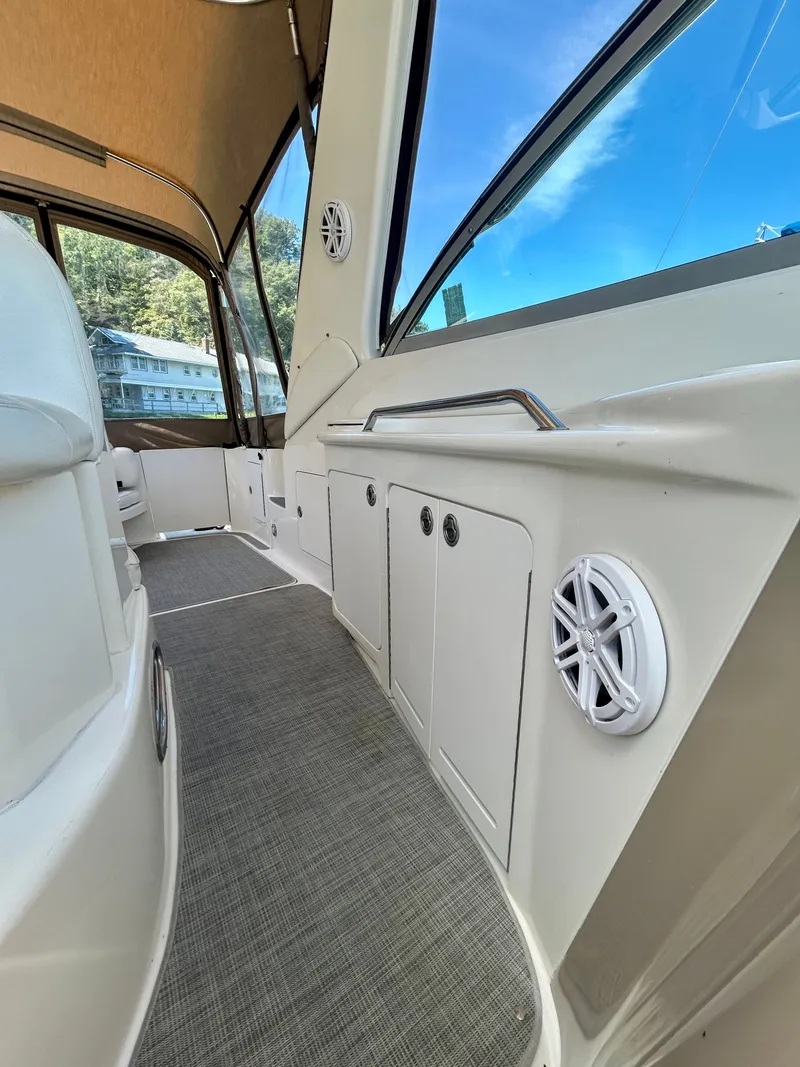 Slide: The Image of Interior view of a 1999 Sea Ray 340 Sundancer with carpeted floor and speakers. - 24