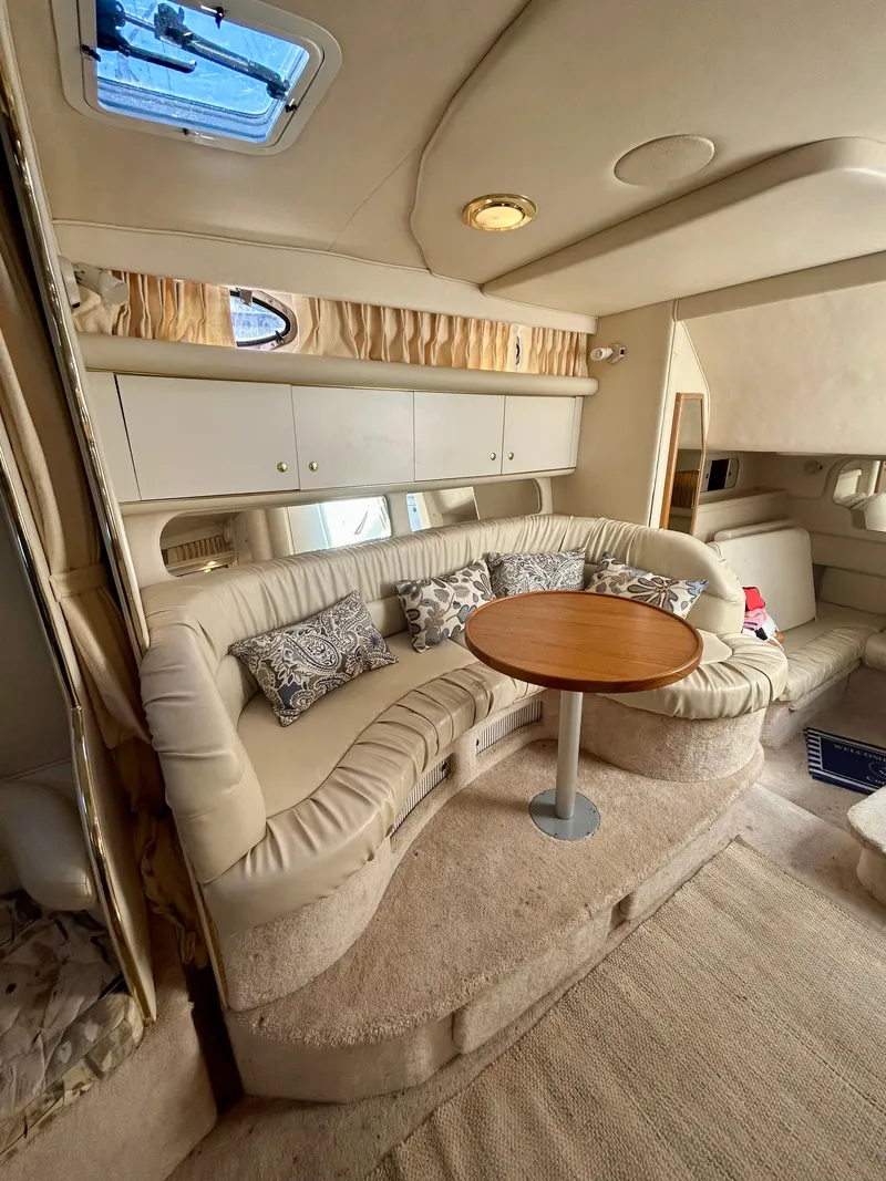 Slide: The Image of Interior of a 1999 Sea Ray 340 Sundancer with beige sofa and wooden table. - 19