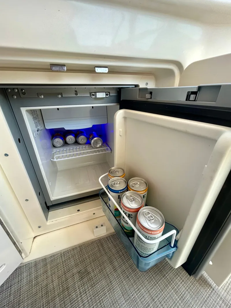 Slide: The Image of A small fridge on a boat with beverage cans inside. - 15