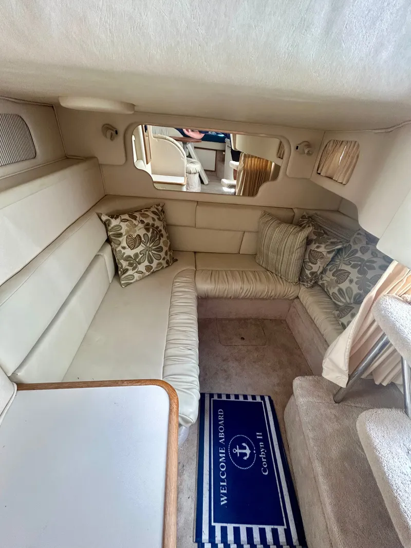 Slide: The Image of Interior of a 1999 Sea Ray 340 Sundancer with beige upholstery and decorative pillows. - 21