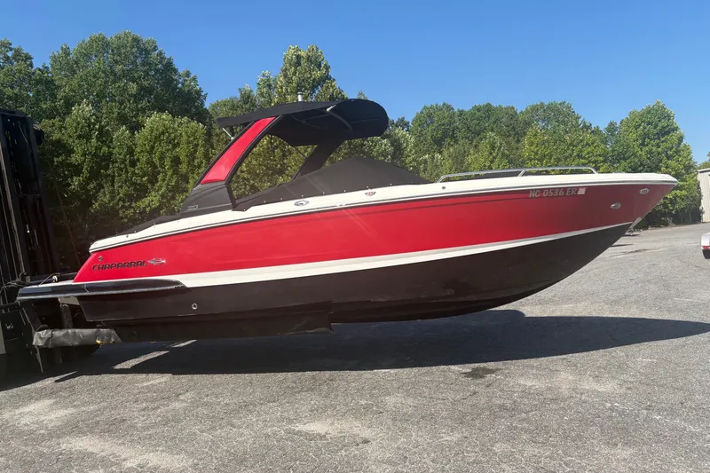 The Image of 2021 Chaparral 267 SSX boat in vibrant red, displayed outdoors on a sunny day. - 0