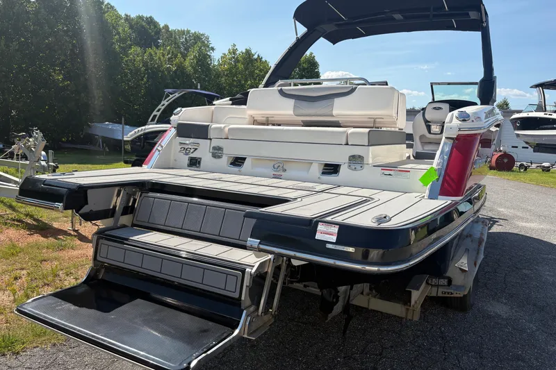 Slide: The Image of 2021 Chaparral 267 SSX boat with extended swim platform and seating, parked outdoors. - 3