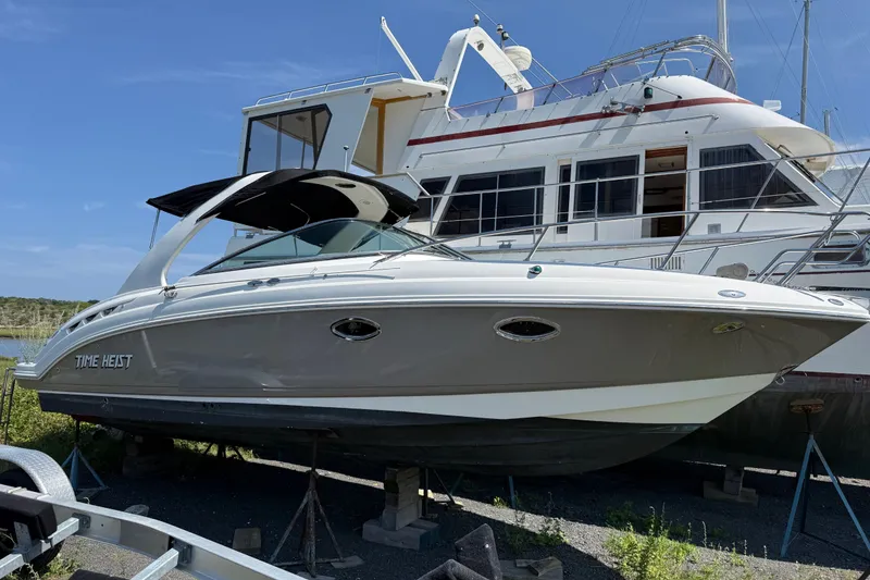 The Image of 2007 Chaparral 275 SSi boat on stands, with a larger yacht in the background. - 1