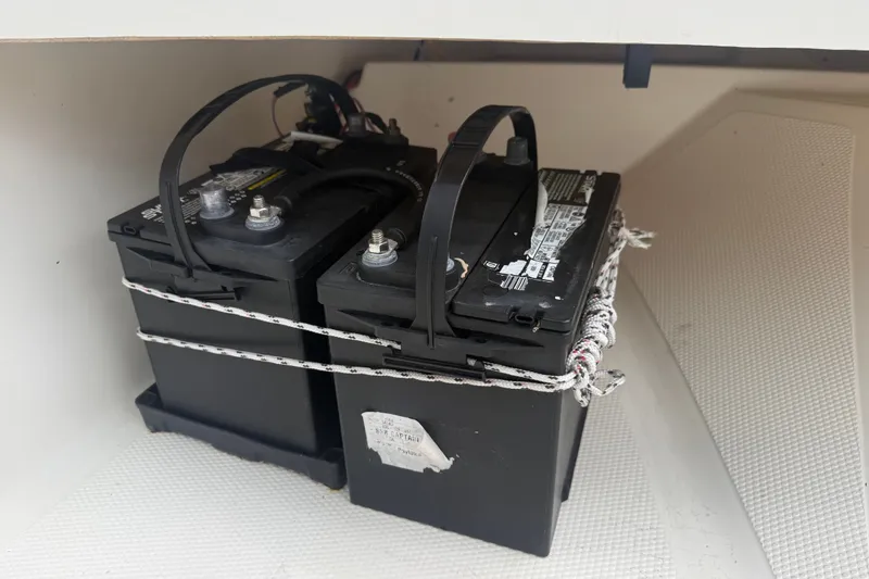 Slide: The Image of Dual marine batteries secured in a 2016 Mako Pro Skiff 16 CC boat compartment. - 24