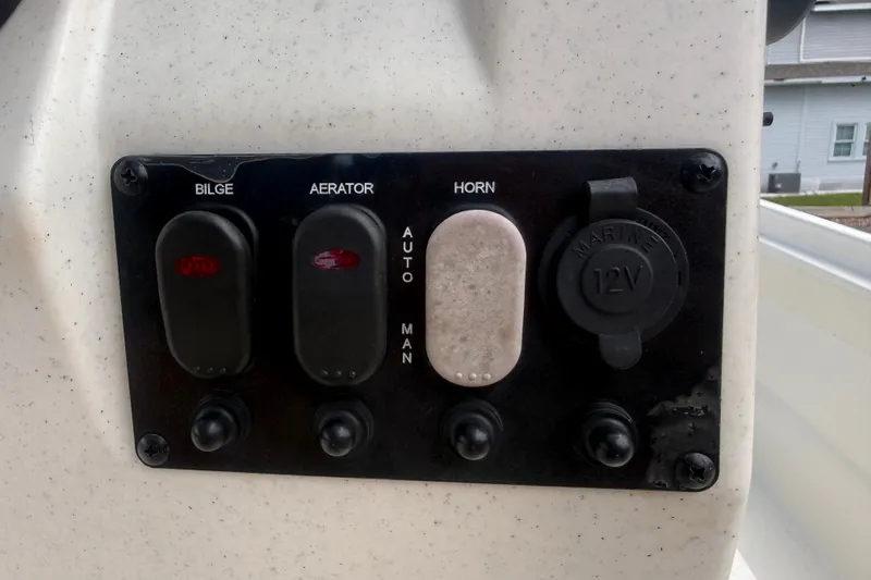 Slide: The Image of Control panel of a 2016 Mako Pro Skiff 16 CC boat with switches and 12V outlet. - 17