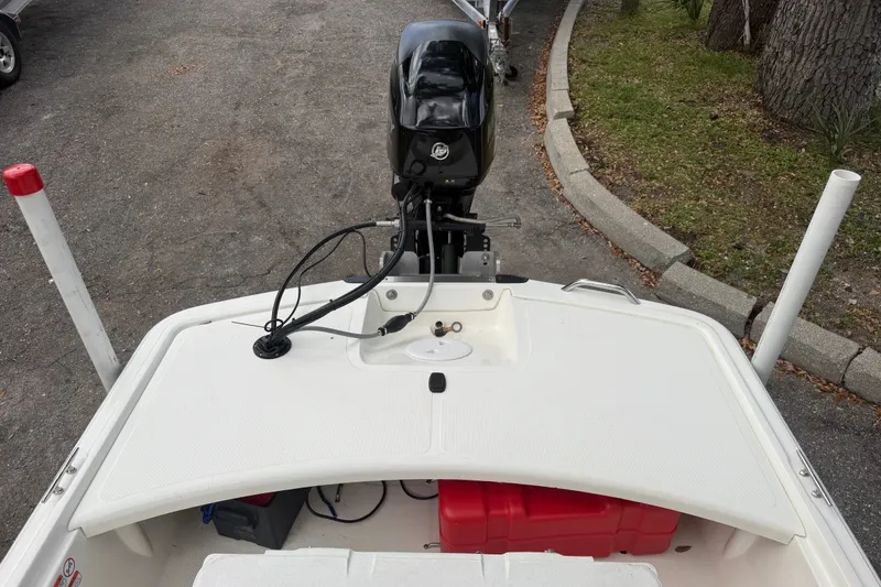 Slide: The Image of 2016 Mako Pro Skiff 16 CC boat with outboard motor, parked on a paved area. - 13