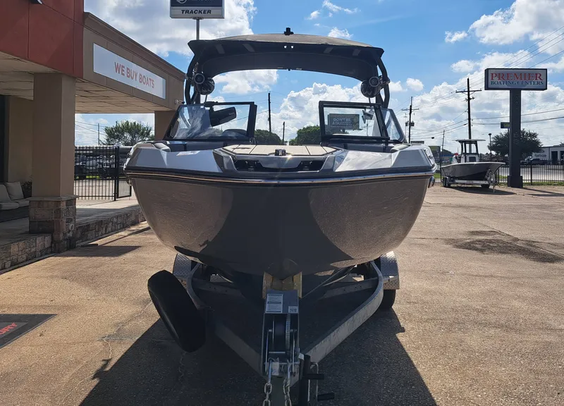 Slide: The Image of A 2025 Yamaha 222XD boat on a trailer in front of a building on a sunny day. - 5