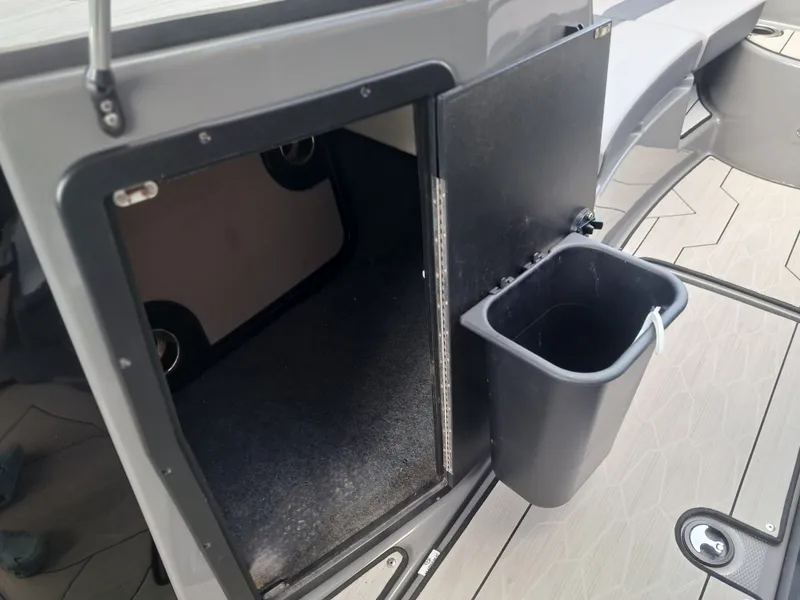 Slide: The Image of An open storage compartment with a trash bin on the door of a boat. - 20