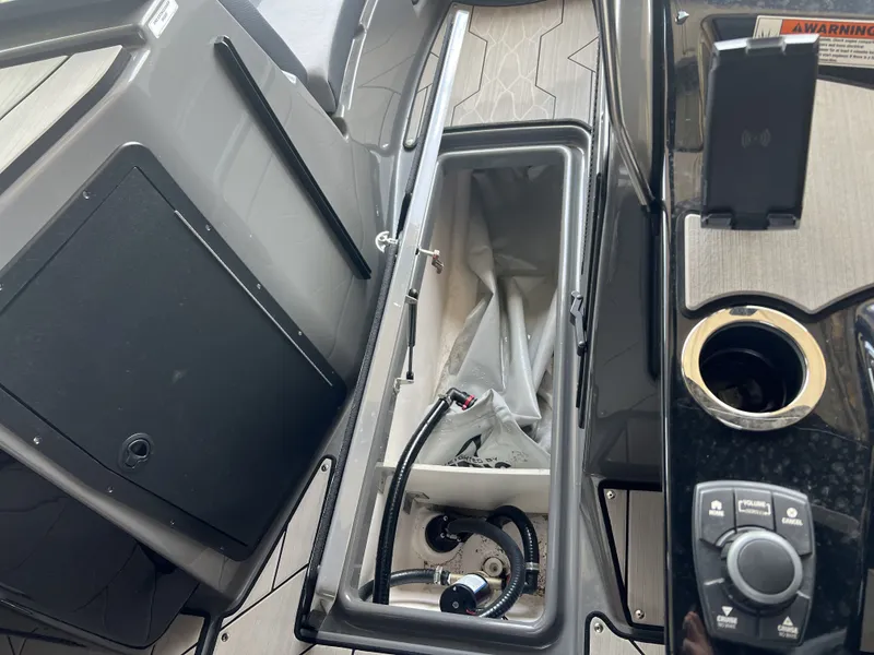 Slide: The Image of The image shows the storage compartment of a 2025 Yamaha Boats 222XD with technical components. - 17