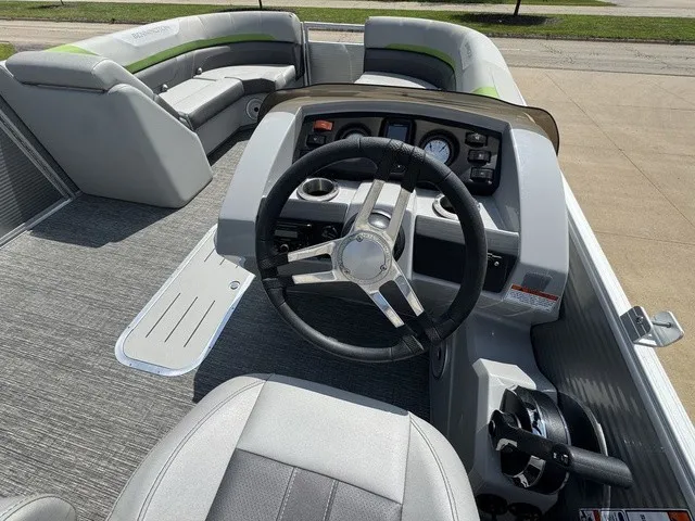 Slide: The Image of The image shows the cockpit of a Bennington 22 SSBX pontoon boat with gray upholstery and a modern helm. - 12