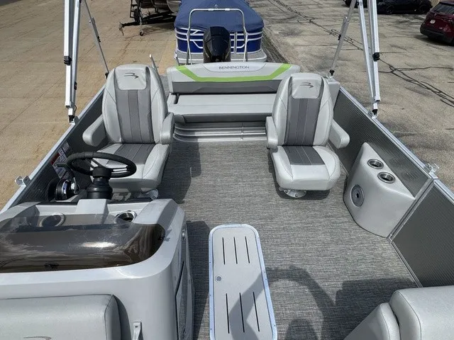 Slide: The Image of The image shows a 2022 Bennington 22 SSBX pontoon boat with gray seating and carpeted flooring. - 14