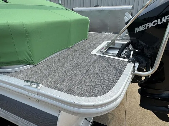 Slide: The Image of The image shows the stern of a 2022 Bennington 22 SSBX pontoon boat with green covers and a Mercury engine. - 5