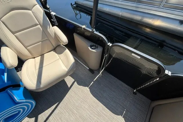 Slide: The Image of Interior of 2022 Manitou 23 Aurora boat with beige seating and cup holder. - 20
