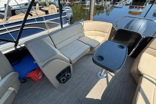 Slide: The Image of Interior of 2022 Manitou 23 Aurora pontoon boat with beige seating and table. - 22