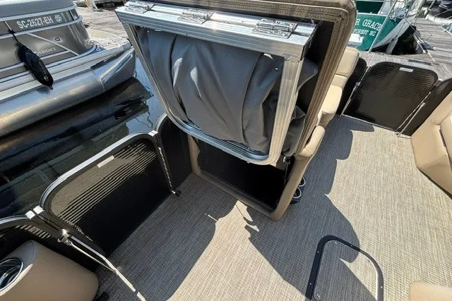 Slide: The Image of 2022 Manitou 23 Aurora boat interior with seating and storage compartments. - 18