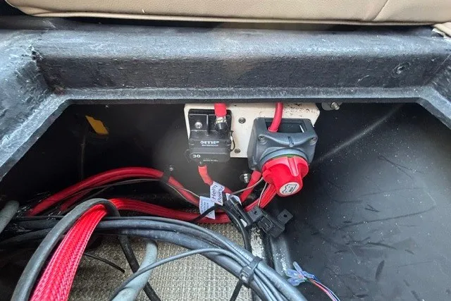 Slide: The Image of Electrical wiring and switches inside a 2022 Manitou 23 Aurora boat compartment. - 27