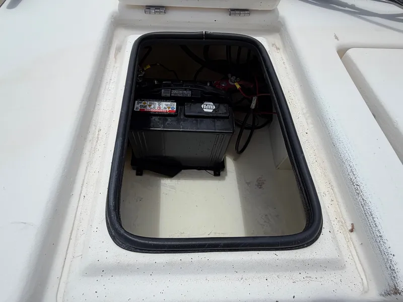 Slide: The Image of An open storage compartment on a 2016 Cape Craft 180cc boat reveals a battery. - 27