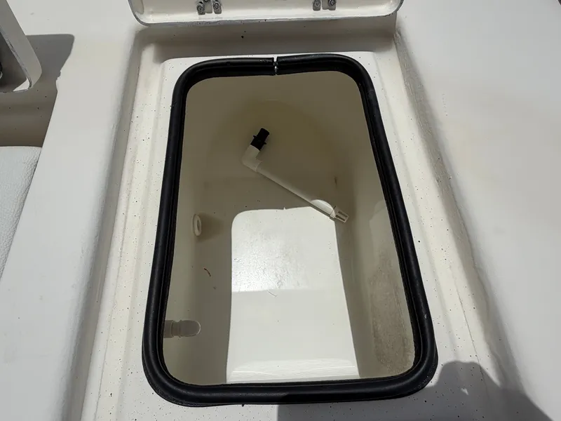 Slide: The Image of An open storage compartment on a 2016 Cape Craft 180cc boat, featuring a white interior. - 25