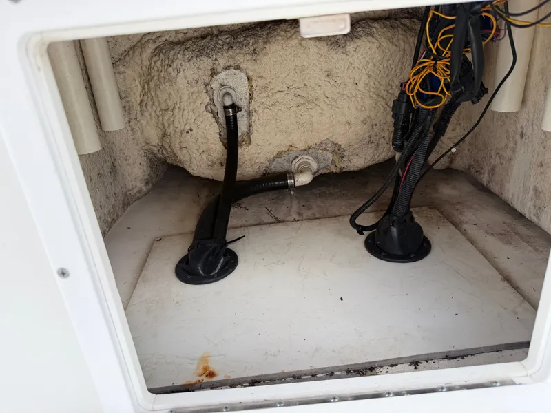 Slide: The Image of An open storage compartment with cables and hoses inside a boat. - 21
