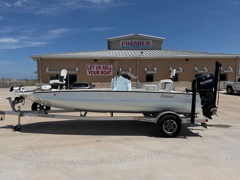 The Image of A 2023 Excel 203 Bay Pro boat on a trailer in front of a boating center. - 1