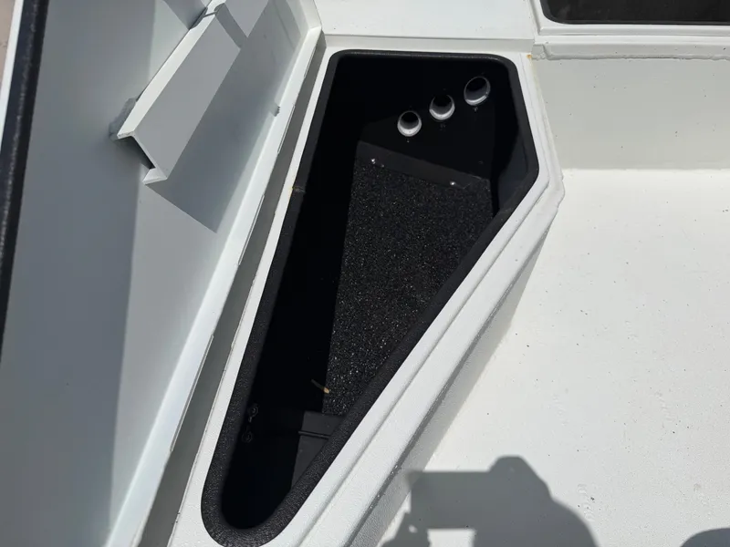 Slide: The Image of An open storage compartment on a boat with a black interior and three round openings. - 14