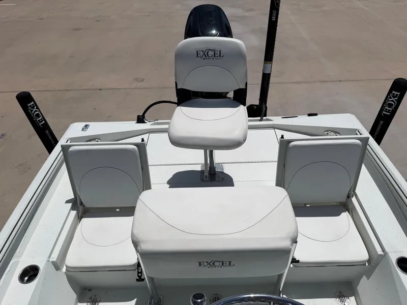 Slide: The Image of The image shows the cockpit of an Excel 203 Bay Pro boat with white seats and a helm. - 27