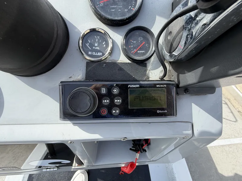 Slide: The Image of Close-up of a boat console area with a Fusion audio system and various gauges. - 17