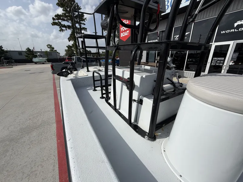 Slide: The Image of The image shows the deck of a 2016 Exuma 17 Island Skiff. It features a clean, white surface with black railings and a seating area. - 16