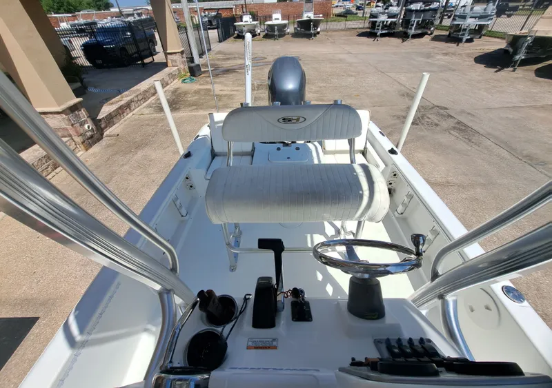 Slide: The Image of The image shows the cockpit of a 2011 Sea Hunt XP21 boat with a helm and seating. - 22
