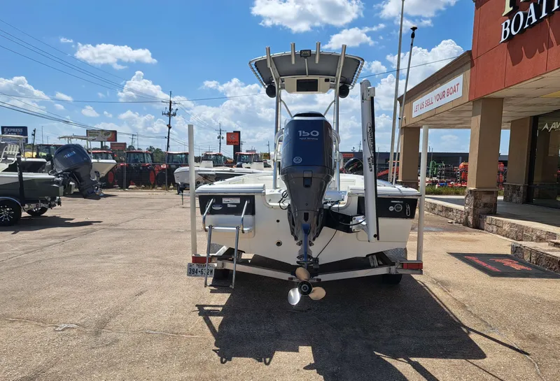 Slide: The Image of Rear view of a 2011 Sea Hunt XP21 boat on a trailer, featuring a 150 HP outboard motor. - 11