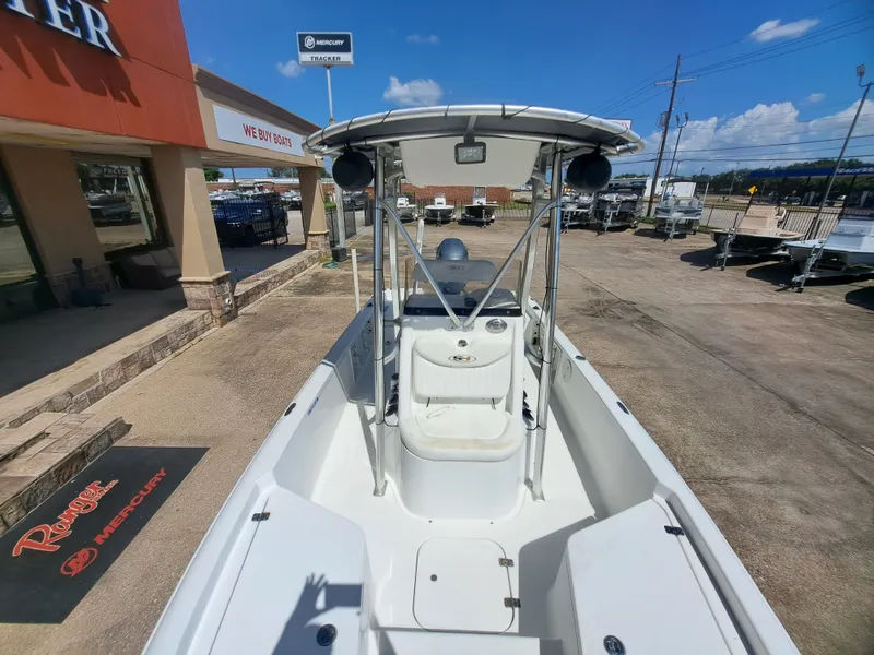 Slide: The Image of A 2011 Sea Hunt XP21 boat is parked outside a store. It features a T-top and open cabin. - 15