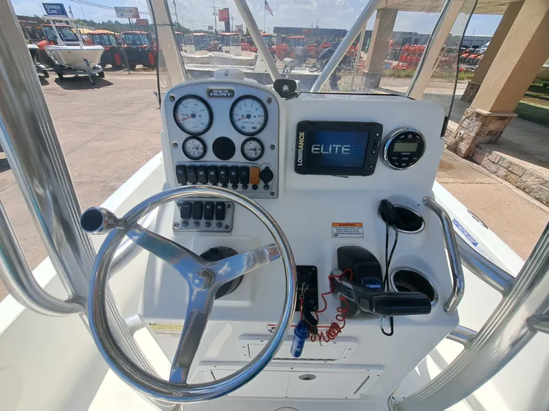 Slide: The Image of The image shows the helm of a 2011 Sea Hunt XP21 boat with various instruments and a steering wheel. - 23