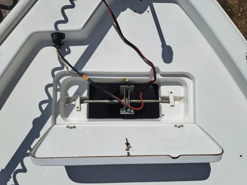 Slide: The Image of An open storage compartment on a boat with wires and a metal mechanism. - 13